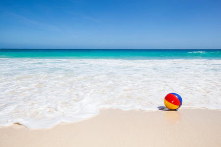 travel background with a colorful water ball at the beach 