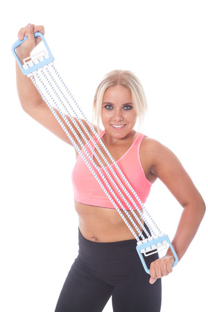young blonde girl training with an expander for physical fitnessの写真素材