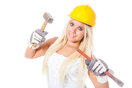 sexy young blonde girl working as a building labor with protection helmet, hammer and gouge or chiselの写真素材