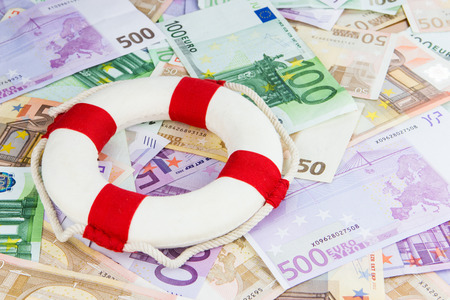 red and white life-saver on Euro banknotes, concept for Euro crisis, cut in interest ratesの写真素材