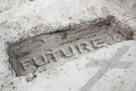Open grave in the desert. In  the sand is written the word future. Concept for no future or end of worldの写真素材