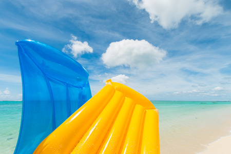 travel background with a yellow and blue air mattress at a beautiful beach with a turquoise sea, Mauritius, Africaの写真素材