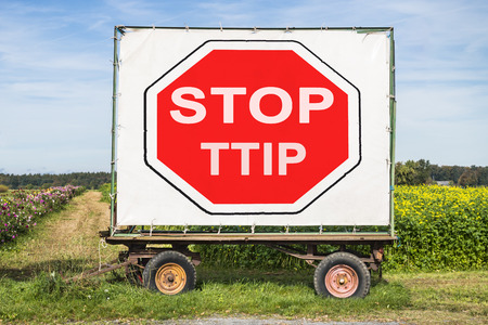rural farm trailer with a big white poster, showing a red stop sign and the words Stop TTIP.Concept for protest of european farmer and customer against TTIP contract with the USの写真素材