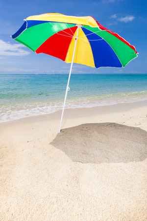 vertical travel background with a colorful sunshade, beach turquoise sea and blue sky, Le Morne, Mauritius, Africaの写真素材