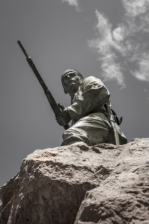 Soldier with gun on the rock of the Marine monument, remembering the German soldiers killed during the Herero rebellion 1904-1905, Swakopmund, Namibia, Africaのeditorial素材