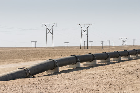 oi, gas or water pipeline and electricity pylons in the namib desert, concept for energy...