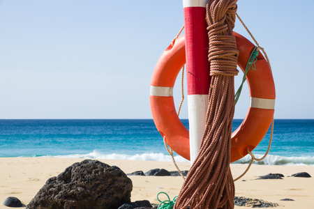 hanging orange life belt with long rope at the beach, security and  safety conceptの写真素材