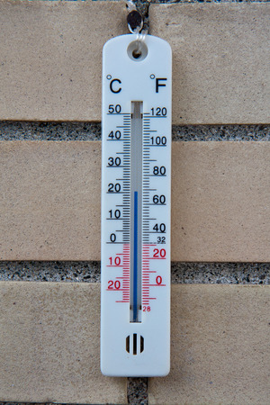A thermometer hanging on white bricks wallの写真素材