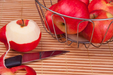 Juicy, ripe, red apples in a metal basket, standing on a table.の写真素材