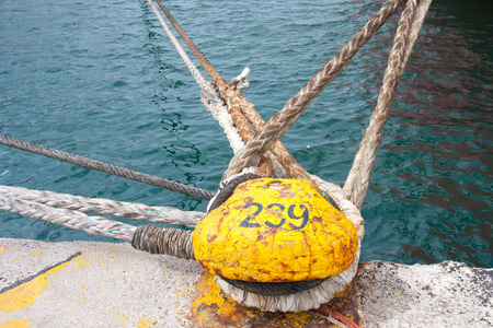 Piraeus, Greece-April 04, 2015: mooring poles braided with mooring ropesの写真素材