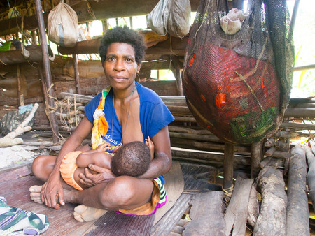 The jungle, Indonesia - January 16, 2015: Residents of a distant jungle in their natural environment. Korowaya tribe. Builders of houses in the trees.のeditorial素材