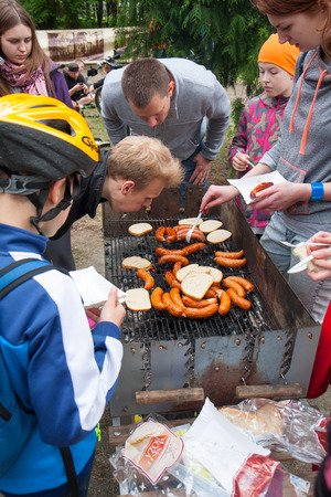 Otwock, Poland-May 23, 2015: Hungry and thirsty people flocking next to the burning grill.のeditorial素材