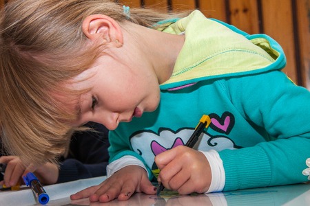 Jozefow, Poland - October 24, 2015:  A small blond-hair  girl is painting artworks with markersのeditorial素材
