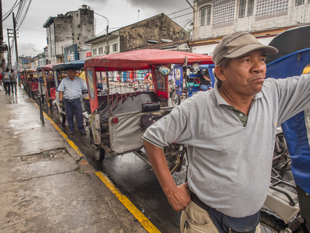 Iquitos, Peru- May 14, 2016: Various rickshaws on a  street of a small town.のeditorial素材
