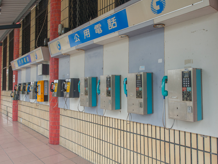 Luodong, Taiwan - October 18, 2016: More than a dozen of phones installed on the wall of a railway station building in Luodongのeditorial素材