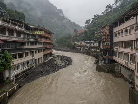 Wulai, Taiwan - October 09, 2016: Landscape of buildings on a misty, rainy and lush hill by a river in Wulaiのeditorial素材