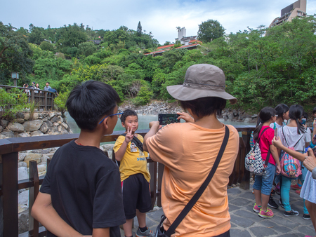 Xinbeitou, Taiwan - October 06, 2016: Taiwanese family take a picture in a background of the natural hot springs in Beitouのeditorial素材