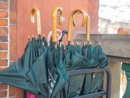 Navy blue umbrellas on a stand in front of a  templeの写真素材