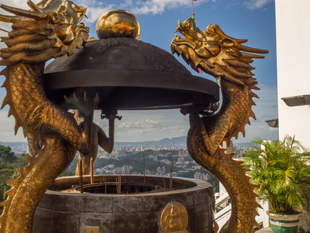 Maokong, Taiwan - October 19, 2016: A golden censer with two handles in the shape of dragons before the Chih Nan Temple on the hills of Maokong  in Taiwan. And view for Taipei Cityのeditorial素材