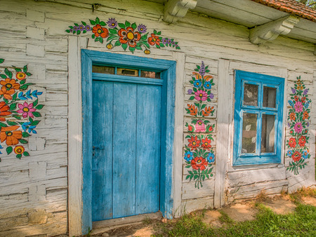 Zalipie, Poland - May  20,  2017: 2017: House with blue frames and colourful flowers painted on  walls in the village of Zalipieのeditorial素材