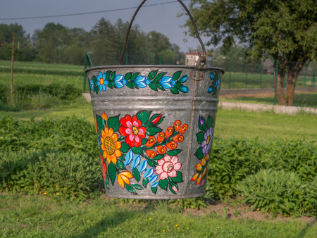 Zalipie, Poland - May 20, 2017: A bucket over a well in the colorful village - Zalipie, heritage park where all buildings and objects are decorated with traditional floral motif.のeditorial素材
