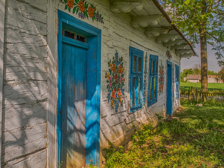 Zalipie, Poland - May  20,  2017: 2017: House with blue frames and colourful flowers painted on  walls in the village of Zalipieのeditorial素材