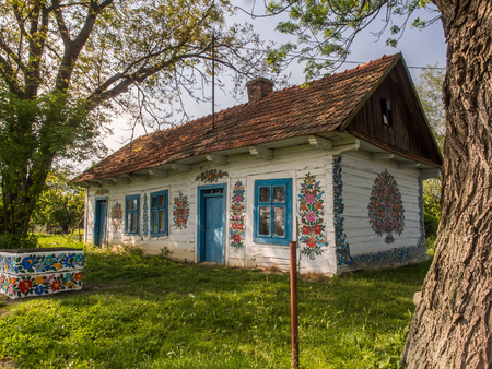 Zalipie, Poland - May  20,  2017: 2017: House with blue frames and colourful flowers painted on  walls in the village of Zalipieのeditorial素材