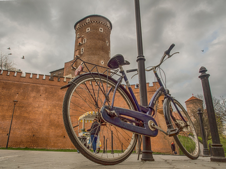 Cracow, Poland - April  03, 2017: A blue bicycle chained to a lamp post with the view to the Wawel in Cracowのeditorial素材