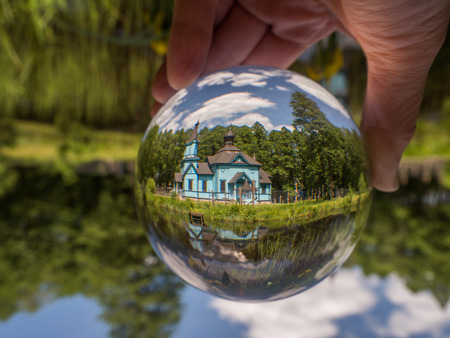 Koterka, Poland - May 20, 2018: Blue, wooden orthodox church reflecting in the glass ball. Podlachia region,の写真素材