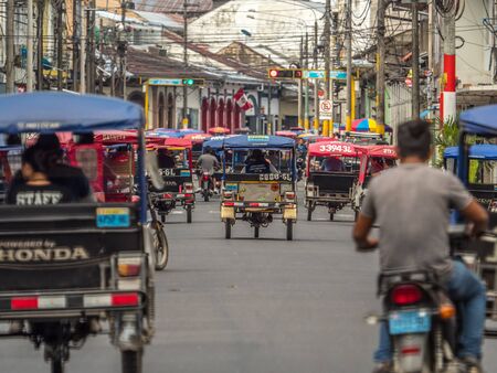 Iquitos, Peru- September 25, 2018: Various rickshaws on a  street of a small town. Latin America.のeditorial素材