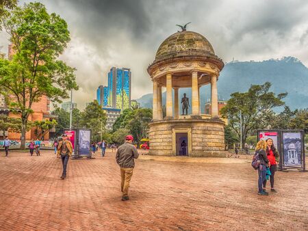 Bogota, Colombia - September 13, 2013: Estatua De Simon Bolivar at Parque de Los Periodistas, Journalists' Park in Bogota and view on the Monserrate Hill and church, Monserrate Monastery and high, modern, blue building. La Candelaria district of Bogotaのeditorial素材