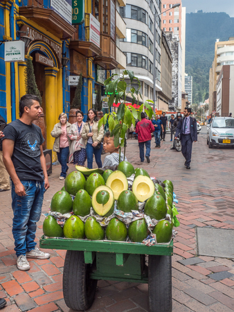 Bogota, Colombia - November 23, 2018: Man selling huge avocado on the street of Bogota. Lifestyleのeditorial素材