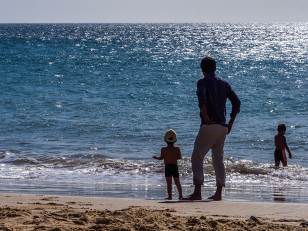 Silhouette of father and chidren on the beach on the background of the ocean. Senegal. Africaの写真素材