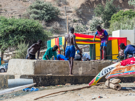 Dakar, Senegal - February 2, 2019: African boys pull water from a well in the fishing village of...