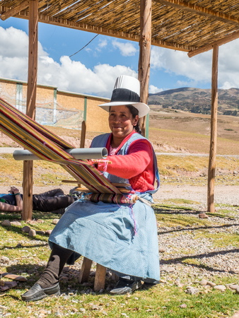 Moray, Peru - May 20, 2016: Quechua woman weaves colorful materiel on looms. South Americaのeditorial素材