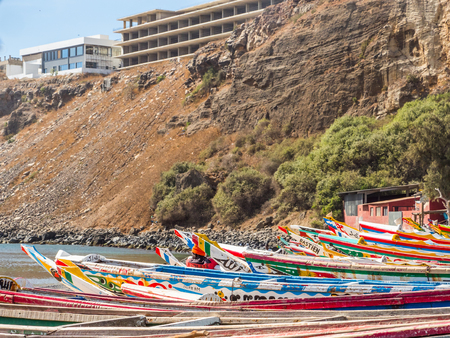Dakar, Senegal - February 2, 2019: Colored, wooden, fisher  boats next to the cliff    in the fishing village of Ouakam, in Dakar, Senegalのeditorial素材