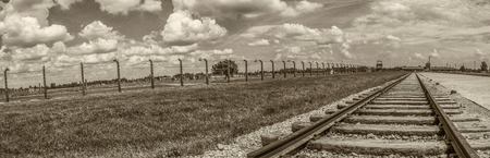 OÅwiÄcim, Poland - June 05, 2019:  Railway tracks and electric fence  in Auschwitz Birkenau Concentration Camp.  Jewish extermination camp. Europeのeditorial素材