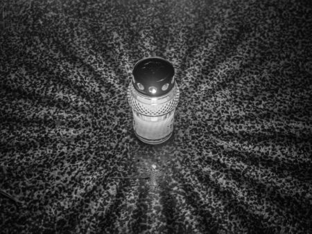 The cemetery torch burns with a bright light in the dark night and others lights in the background