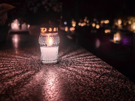 The cemetery torch burns with a bright light in the dark night and others lights in the backgroundの写真素材