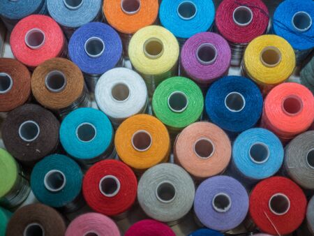 A lot of sewing colored thread. Thread reels. Colorful threads in the box. Texture of sewing accessoriesの写真素材