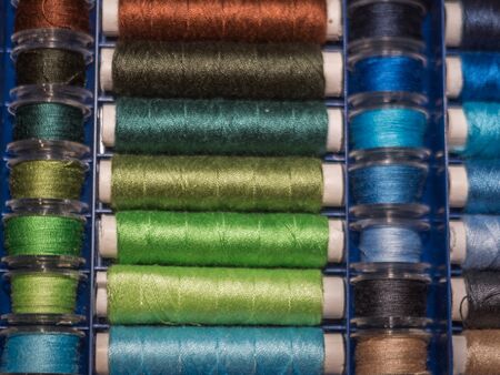A lot of sewing colored thread. Thread reels. Colorful threads in the box. Texture of sewing accessoriesの写真素材