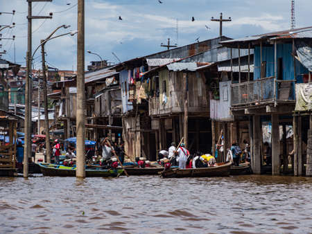 Belen, Peru- Dec 2019: People on the boats between floating houses in the floodplain of the Itaya River, poorest part of Iquitos - Belén. Venice of Latin America. Iquitos, South America, Amazoniaのeditorial素材