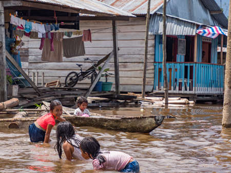 Belen, Peru- Dec 2019: Children are playing in the water between floating houses in the floodplain of the Itaya River, poorest part of Iquitos - BelÃ©n. Venice of Latin America. Iquitos, South America. Amazoniaのeditorial素材