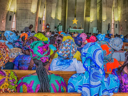 Senegal, Africa - January 2019: African people in colorful clothes (boubou) during a mass at a Catholic church in West Africaのeditorial素材