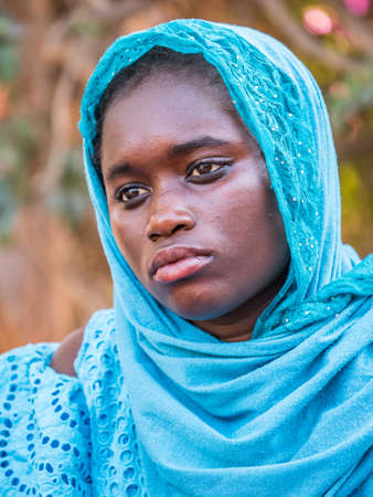 Senegal, Africa - Jan, 2019: Portrait of a beautiful Senegalese woman in a traditional costume called 'boubou' and a swing on her headのeditorial素材