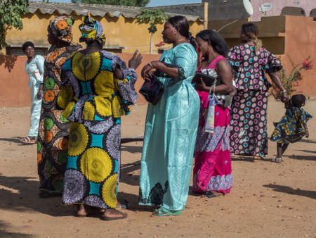 Senegal, Africa - January 2019: African women in their colorful clothes (boubou) meet after the mass...