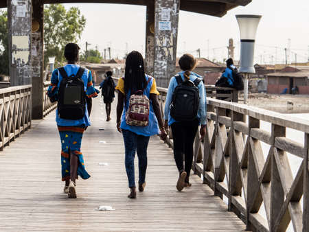 Senegal, Africa - Jan 2019: A group of schoolchildren in blue uniforms on the street Joal-Fadiouth town. Commune in the ThiÃ¨s Region at the end of the Petite CÃ´te of Senegal. Africa.のeditorial素材