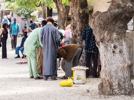 Joal-Fadiout, Senegal - January, 26, 2019: Street seller on the seashell island. Joal-Fadiouth town and commune in the ThiÃ¨s Region at the end of the Petite CÃ´te of Senegal. Africa.のeditorial素材