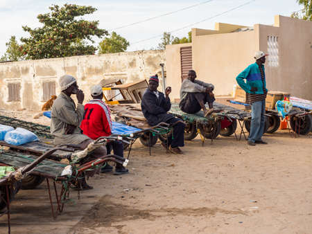 Joal-Fadiouth, Senegal - January 24, 2019: African men waiting with the carts next to island...