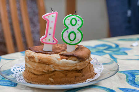 The 18th birthday celebration cake and four glasses of wine on the table. Selective focus.